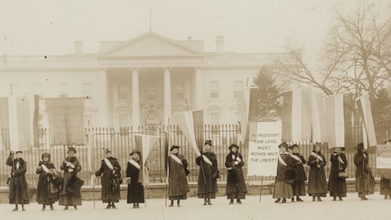 Suffragists on picket line in front of the White House, circa 1917. One banner reads: "Mr. President How Long Must Women Wait For Liberty".  Library of Congress